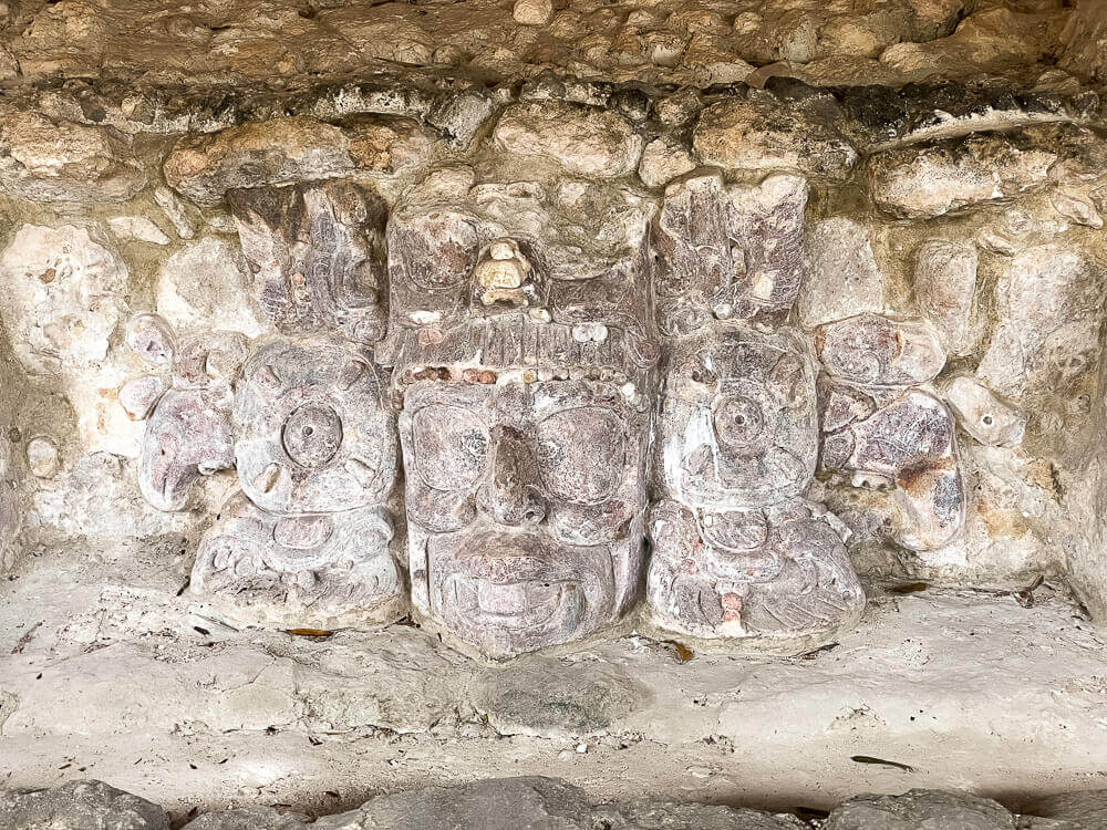 Ancient stucco face masks with other symbols on either side