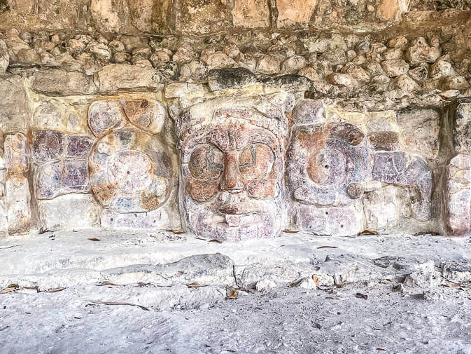 Ancient stucco face masks with other symbols on either side