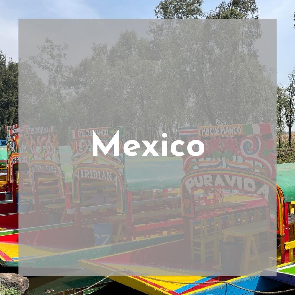 Foreground: a transparent grey box with Mexico in white text Background photo: close up on colorful boats with red trim and green covers.