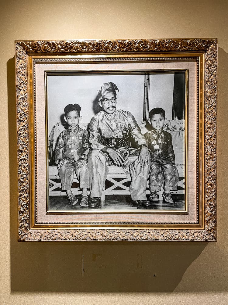 Black and white photo of a man and two young boys in a gold frame