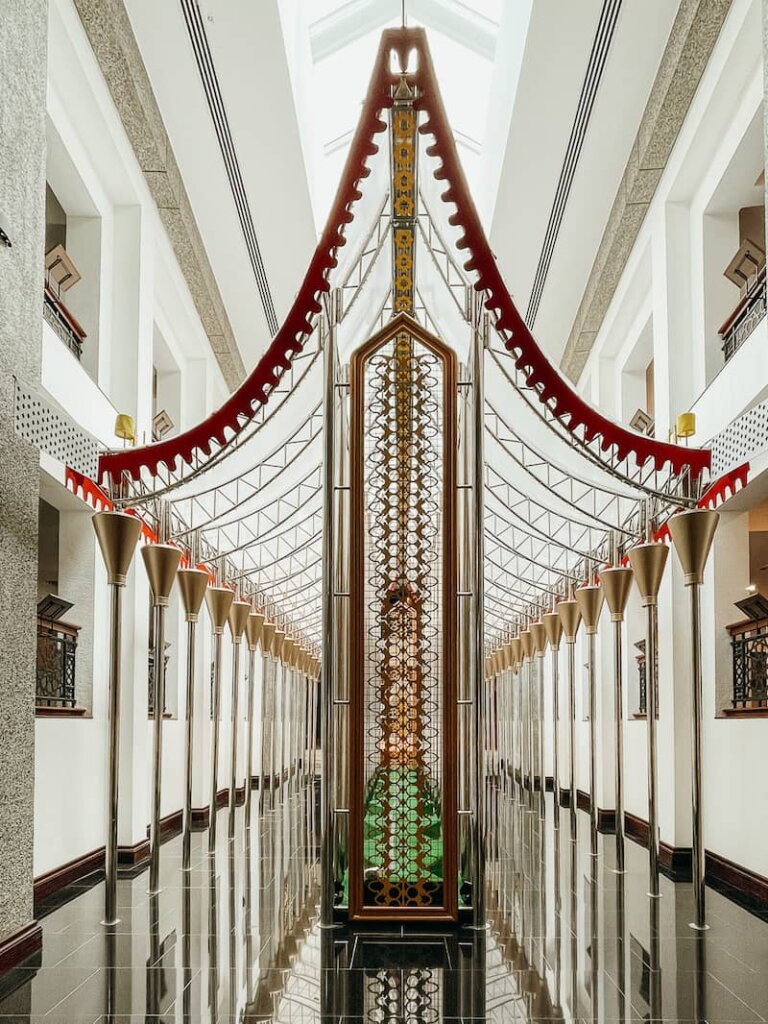 An intricate metal structure rises up to a pointed roof.