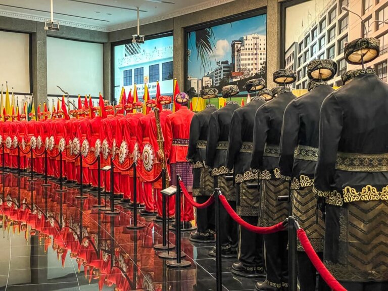 a long row of mannequins in red and black uniforms stretches into the distance