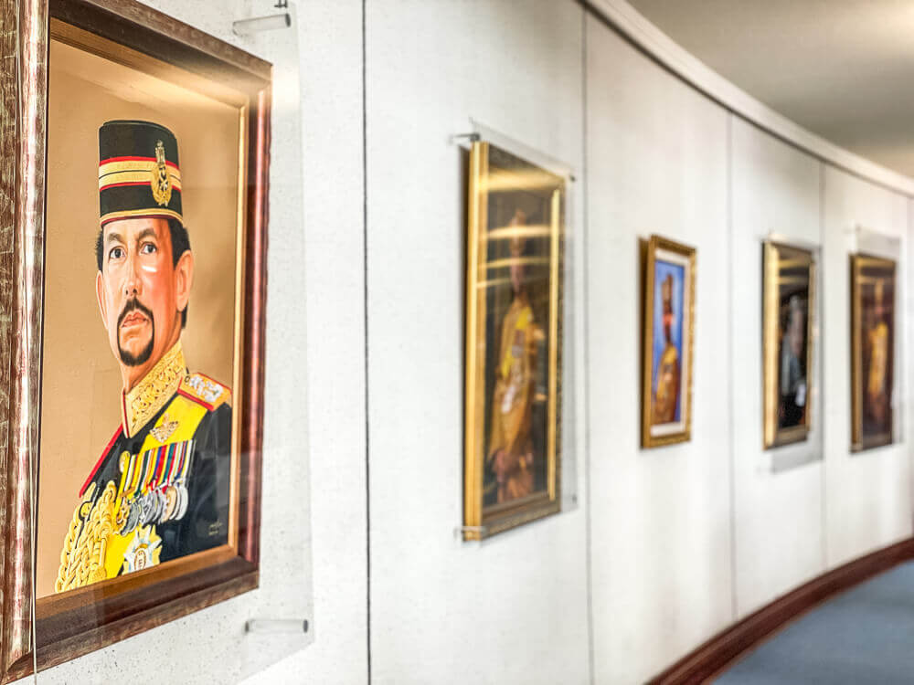 A wall of portraits fading into the distance on a white wall.