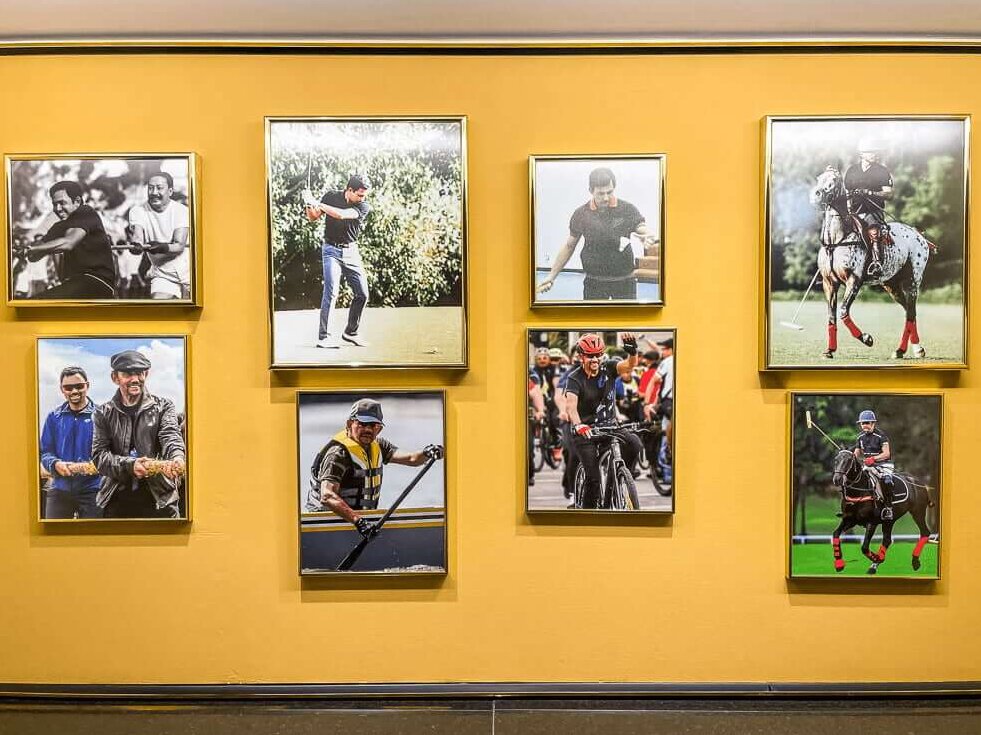 A yellow wall with pictures of a man doing a variety of sporting activities.