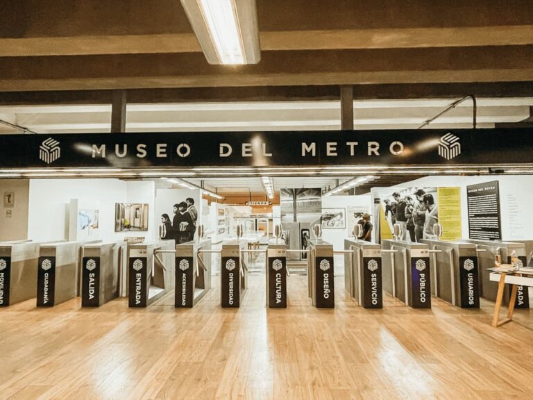 A wide row of turnstiles leads to a room filled with exhibits