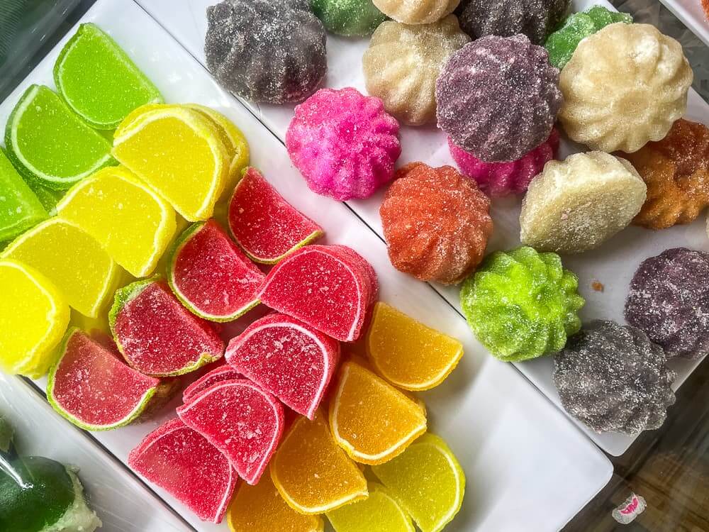 Rectangular plates filled with colorful jelly fruit covered in granulated sugar.