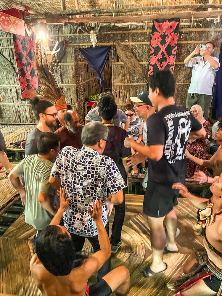 A group of men in motion jumping up in a wooden room.